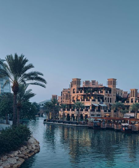 a body of water surrounded by buildings and palm trees dubai